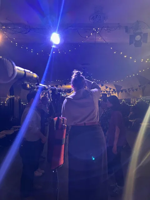 Gäste tanzen gemeinsam einen Ceilidh unter Lichterketten
